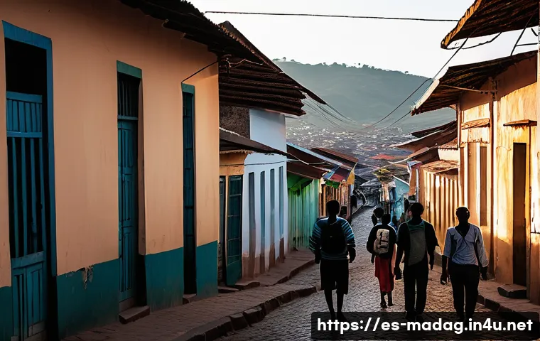 마다가스카르에서 피해야 할 장소 - A dimly lit urban street scene in Antananarivo at dusk, showing a small group of tourists walking ca...